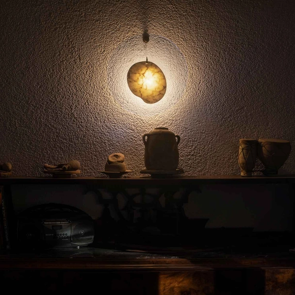 Lampada da parete con elemento in marmo collocato al centro di un disco in polimetilmetacrilato trasparente Gem di Foscarini